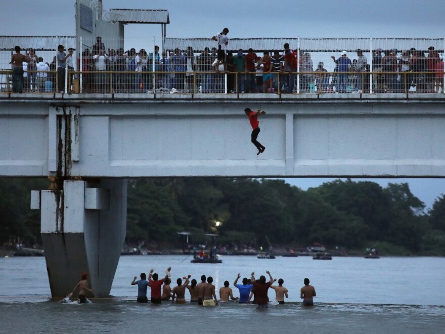 An migrant jumps off a bridge to enter Ciudad Hidalgo, Mexico, from Guatemala on Saturday.