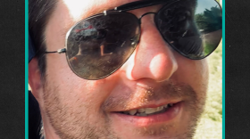 Photo of Marc Smith smiling with a teal border around the photo over a black-ish background