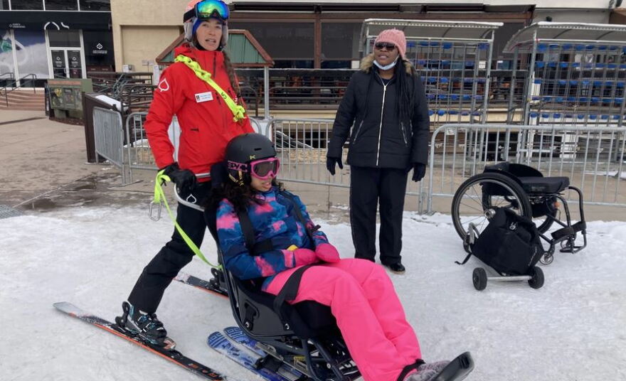 Cami Crady, left, prepares to lead Asia Jami down the Snowmass ski area in a sit-ski. Asia’s friend Valerie Wardwick waits alongside them to watch the first run.