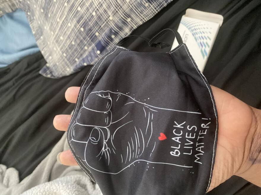 face mask with a raised fist and words Black Lives Matter