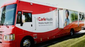 A red mobile clinic bus from Carle Health.