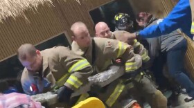 Bloomington firefighters and Miller Park Zoo staff move the zoo's python during Monday night's fire. The source of the smoke was coming from the python enclosure, fire officials said.