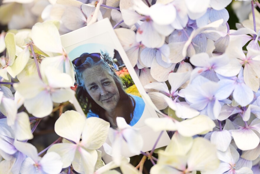 A photo of Ashley Whitehead, one of the victims, is seen on a bed of flowers at a growing memorial following a July 26 shooting at Seattle Center during the Bite of Seattle food festival, Tuesday, July 28, 2026, in Seattle. (AP Photo/Lindsey Wasson)