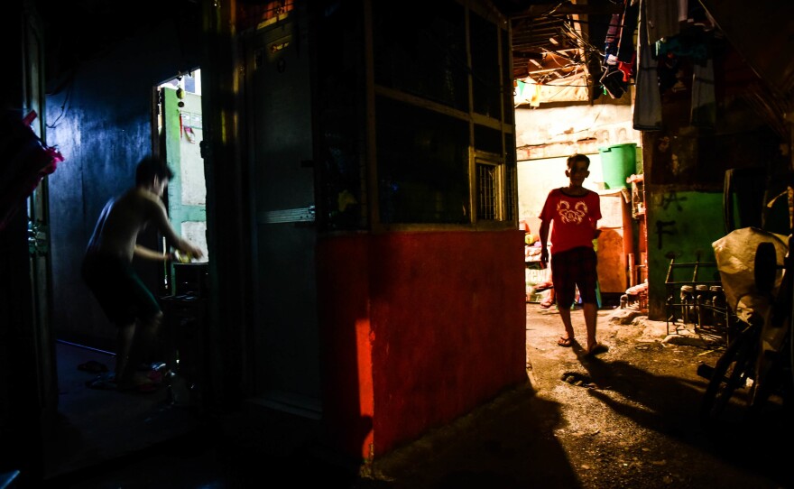 A man walks down a small street in the Arellano district of Manila.