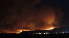 A wildfire crests over the hills above Los Alamos National Laboratory in New Mexico overnight Sunday. (Luis Sanchez Saturno/The New Mexican/Associated Press)