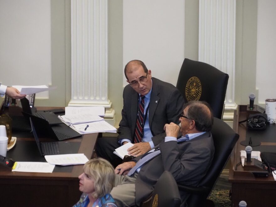 Rep. Tom Gann, R-Inola, left, pulls out a rule book, as Rep. Rick West, R-Heavener, looks on during the House session on May 22, 2025.