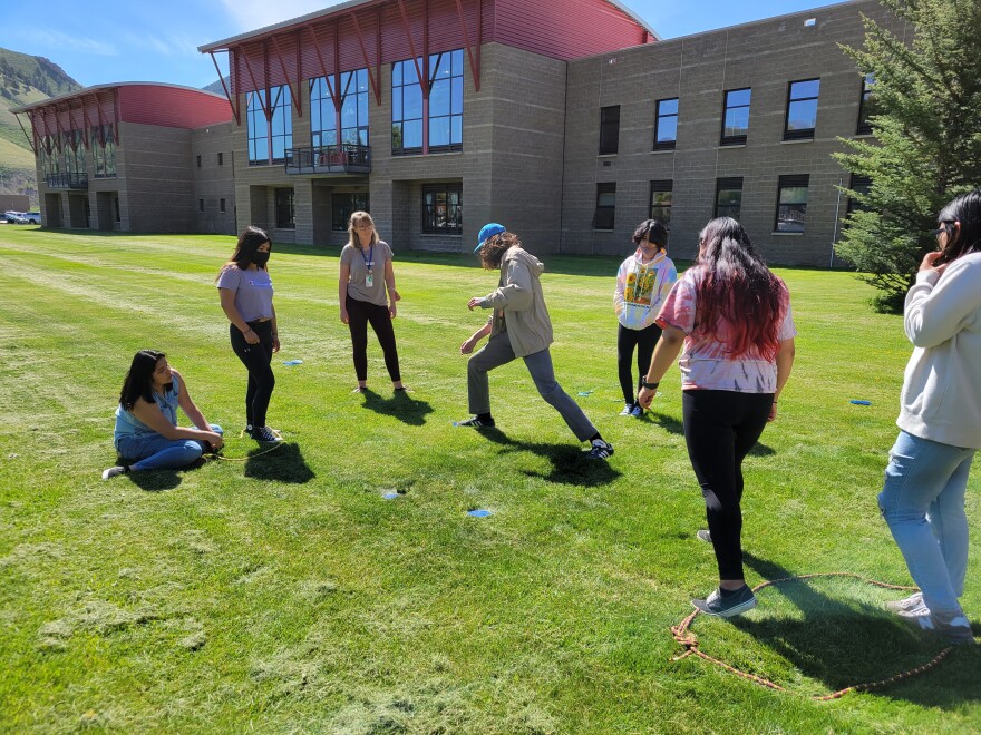 A group of teenagers, standing outside in a circle