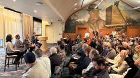 A panel talks in front of a crowd in Everett town hall.