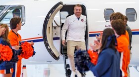 man gets off private plane greeted by cheerleaders in orange and blue 