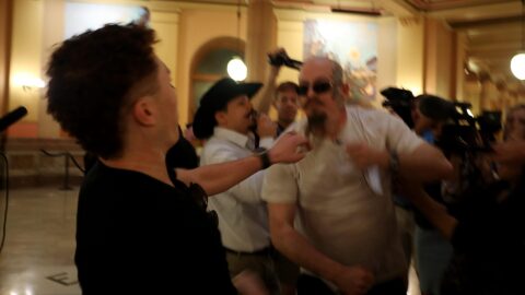 Satanic Grotto president Michael Stewart punches counterprotester Marcus Schroeder after Schroeder attempted to take Stewart's prayer materials during a March 28, 2025, "black mass" inside the Kansas Capitol.
