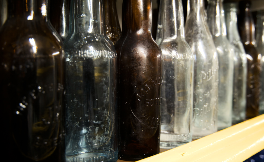 A collage of photos showing some of Frank Harchak's collection of glass bottles