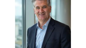 Dr. Robert Steele stands in a blue suit looking at the camera smiling