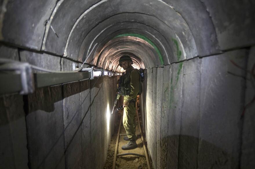 An Israeli army officer gives journalists a tour on July 25 of a tunnel allegedly used by Palestinian militants for cross-border attacks, at the Israel-Gaza border.