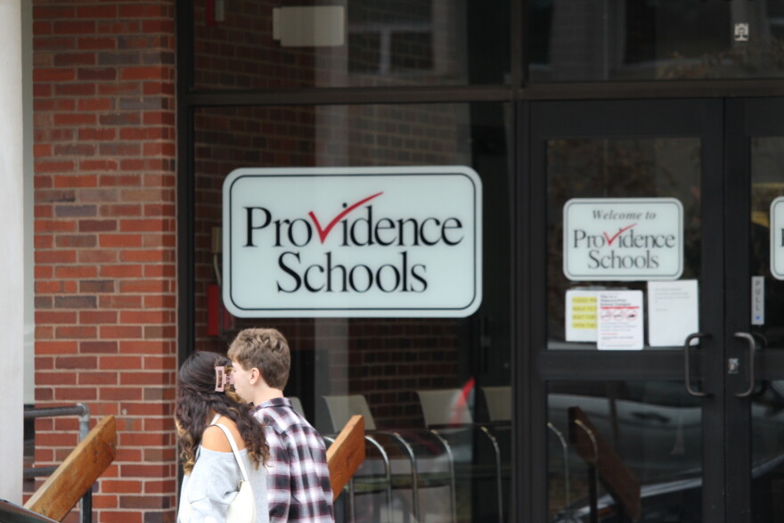 Students walk past a Providence Public Schools sign. The district continues to struggle with low reading and math scores as questions about its leadership emerge after seven years of state control. Credit: Ben Berke/Ocean State Media
