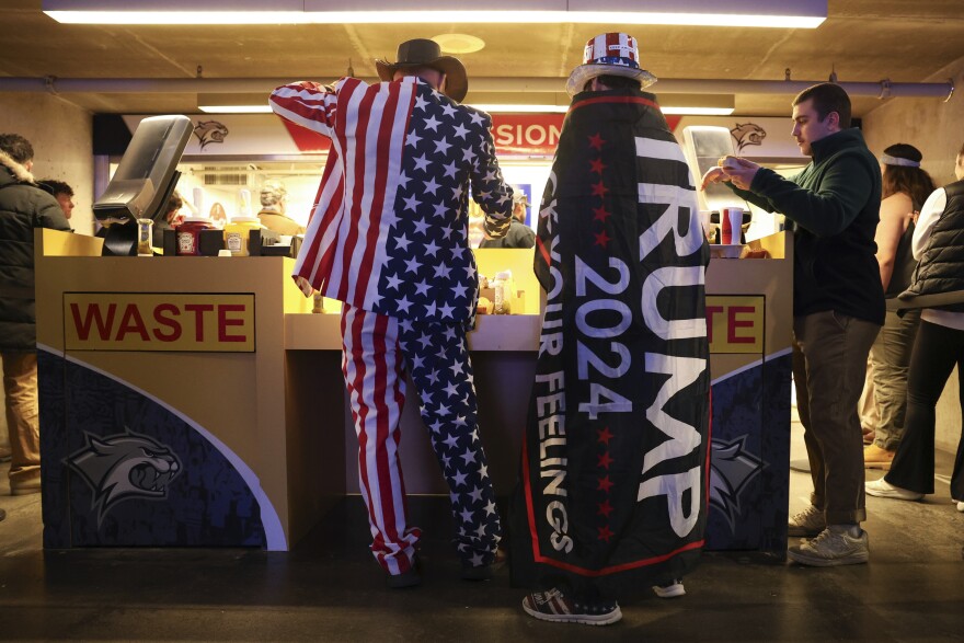 An attendee buy food during a campaign rally for Former president Donald Trump Saturday Dec. 16, 2023, in Durham.