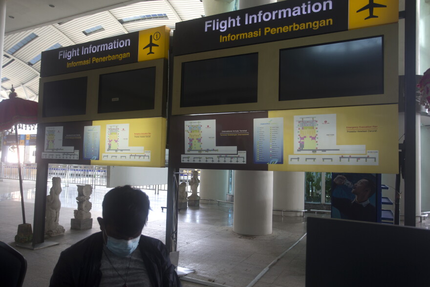 Flight information screens are blank at International Ngurah Rai Airport before its reopening in Bali, Indonesia, Thursday, Oct. 14, 2021. (AP Photo/Firdia Lisnawati)