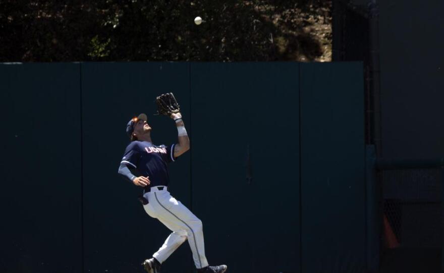 Connecticut right fielder Casey Dana catches a sacrifice fly by Stanford's Brett Barrera in foul ground during the first inning of an NCAA college baseball tournament super regional game, Monday, June 13, 2022, in Stanford, Calif. Brock Jones scored on the out.