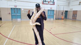 Washtenaw Intermediate Middle School Principal Charles Davis Jr. makes friends with a python named Summer.