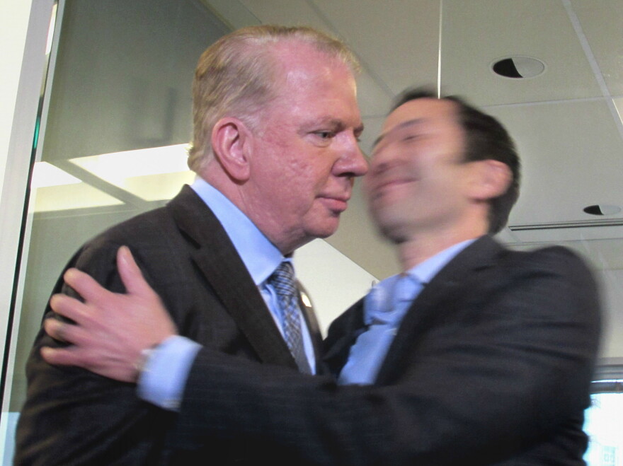 Mayor Ed Murray, left, on Friday afternoon after denying accusations of rape. His husband gave him a quick embrace as he left the podium.
