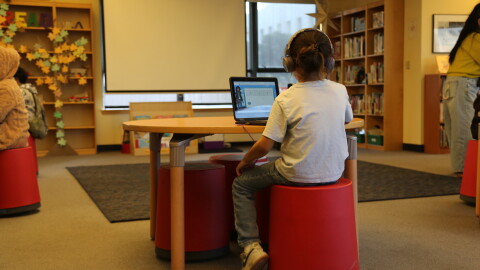 A student at Tenderloin Community Elementary School practicing reading with Amira.