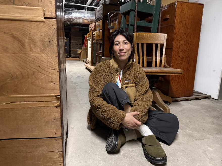 Chrissy Shimizu, the Wing Luke Museum's Executive Director, sits on the floor of the basement inside the Wing Luke Museum. Shimizu said she spent a lot of time there when she fundraised for the museum from 2017 to 2021.