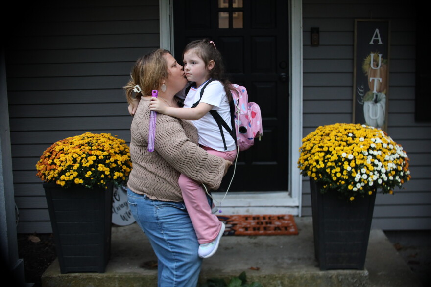 Angela Hausman and 7-year-old Everly, a child she is in the process of adopting, stand in front of their Olathe, Kansas, home on October 14, 2026.