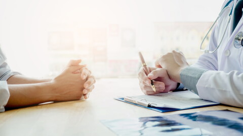 Stock photo. Doctor and patient sit and talk.