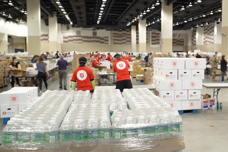 Volunteers from the Salvation Army, Midwest Food Bank, The Indiana National Guard and Lucas Oil Stadium pack food boxes.