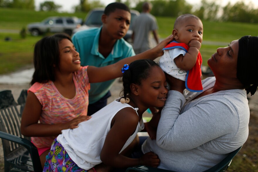 Shannel Battle holds her 3-month-old grandson, Levi Harvey, as family members (clockwise) Diamond Howard (white shirt), 6, Shannair Battle, 12 and Dwayne Howard, 10, shower affection on the baby in 2015. The community of oyster fishermen in their town of Pointe a la Hache was severely affected by the longer-term impact of the 2010 spill.