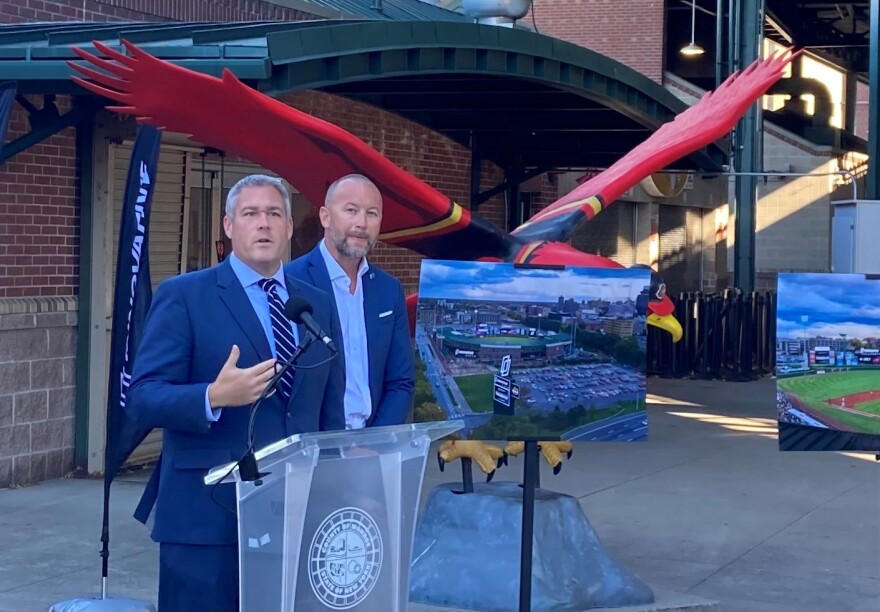Adam Bello stands to the right of Justin Copie in front of the entrance to Frontier Field