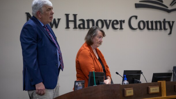 Board members David Perry, left, and Judy Justice, right, listen to God Bless America before the start of the New Hanover County Schools Board of Education meeting in Wilmington on July 8, 2025. Many teachers and community members attended to show their support for the Mary W. Howe Pre-K Center which was under consideration for closure.