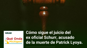 En la imagen se puede observar un mazo de juez de madera.  En el lado inferior de la imagen esta el logo de Que Onda Michigan sobre un fondo blanco. En la parte derecha las siguientes palabras estan escritas: "Como sigue el juicio del ex oficial Schurr, acusado de la muerte de Patrick Lyoya."  y "Episodio 70".