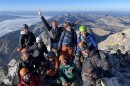 A group of women pose at the top of the Grand Teton with smiles all around.