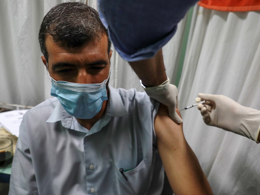 A Palestinian medic administers a dose of the Pfizer-BioNTech COVID vaccine during an inoculation campaign at a medical center in Gaza City on Aug. 23. [Majdi Fathi / NurPhoto via Getty Images]