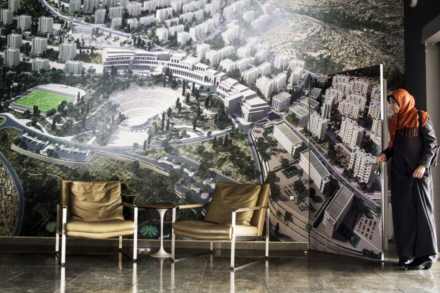 A Rawabi visitor exits the bathroom, which blends in with the photo of the new town.