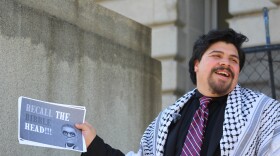 Juan Diaz, the Clevelander who filed a petition to recall Mayor Justin Bibb, holds up a sign that reads, "Recall the Bibble-head!!!"