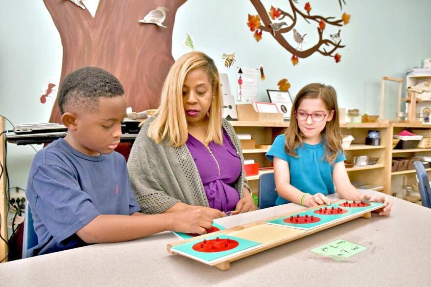 City Garden Principal Nicole Evans working with 4th graders Shannon Seals and Maya Gante' both 9 on how to do fractions. 