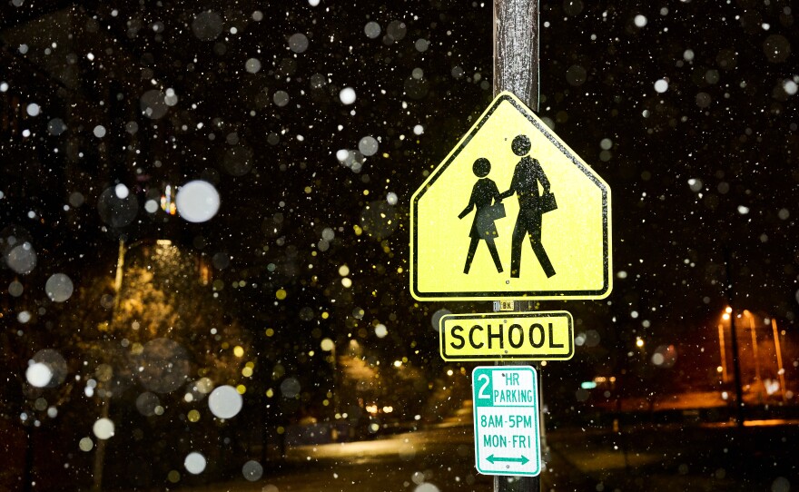 A school crossing sign in the snow in downtown Raleigh.