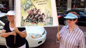 Supporters of a proposed amendment to the U.S. Constitution hold a sign mocking U.S. Supreme Court decisions on campaign finance.