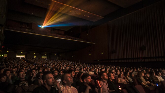 People sit in a theater watching a movie.