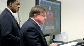 Attorneys from left to right, Dohn Williams and Longworth Butler represent murder suspect Dayonte Resiles as he appears via video conference before Broward Judge Michael Davis, in Fort Lauderdale, Fla., Thursday, July 21, 2016. After nearly a week on the lam, Resiles, who slipped from his shackles and bolted from a crowded South Florida courtroom in a meticulous escape plot involving multiple accomplices was captured at a nondescript motel, authorities said Thursday. (Mike Stocker/South Florida Sun-Sentinel via AP)