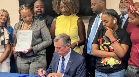Gov. John Carney signs two pieces of police reform legislation at the Wilmington Police Athletic League.