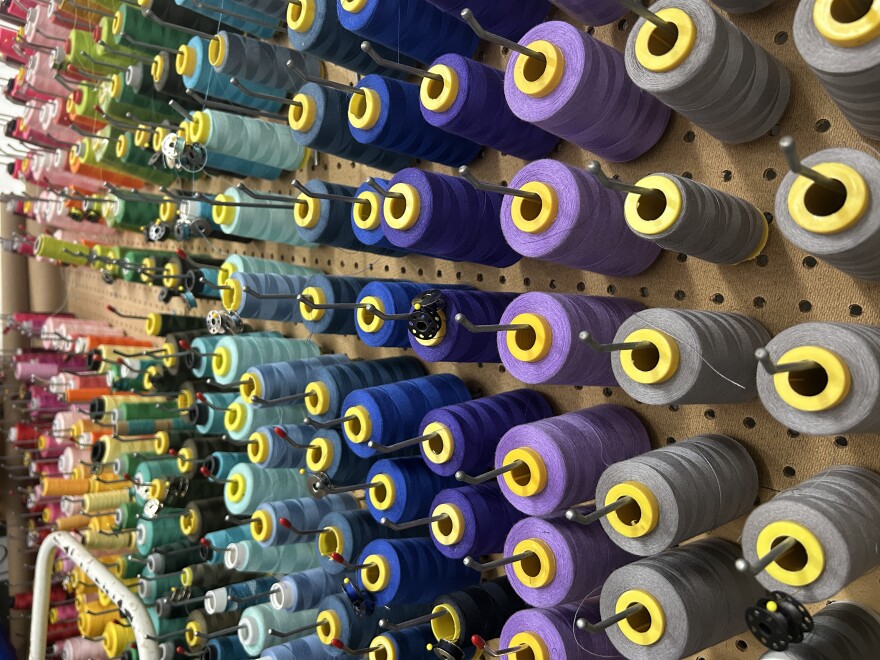 Colorful spools of yarn sit on racks at Stitch Texas, a textile studio in Austin, Texas.