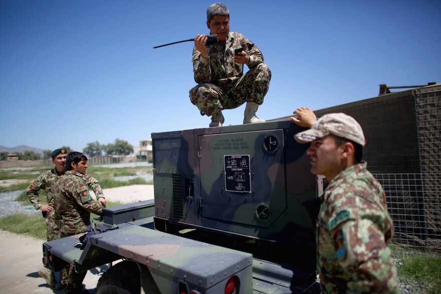 Afghan army battalion commander Lt. Col. Ghani Khel talks with his soldiers after a successful strike on a Taliban truck and rocket launcher.