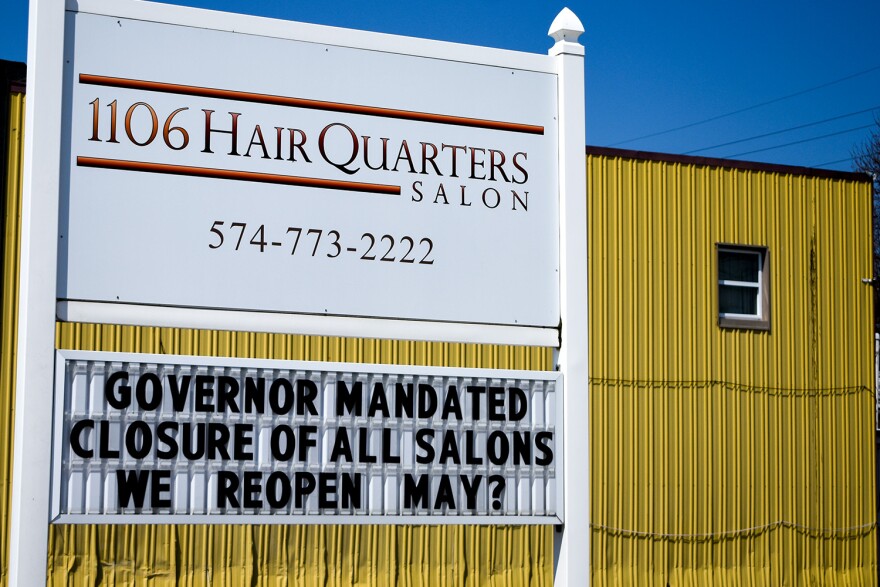 A hair salon in Nappanee displays a closure sign without a clear reopening date. The state's "Stay-At-Home" order has been extended to May 1.