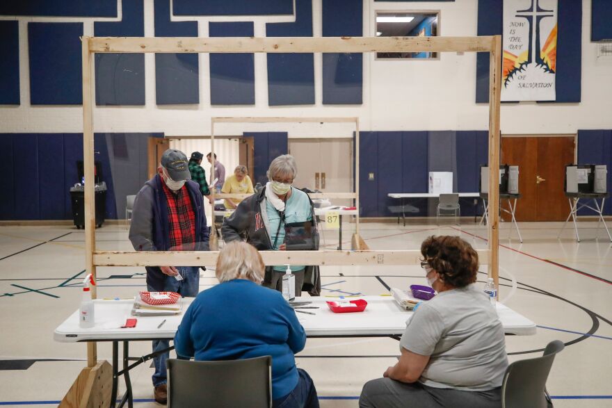 A couple checks in to cast their ballots earlier this month in Kenosha, Wis. Voters went to the polls despite the coronavirus pandemic after courts refused the governor's request to delay the election.
