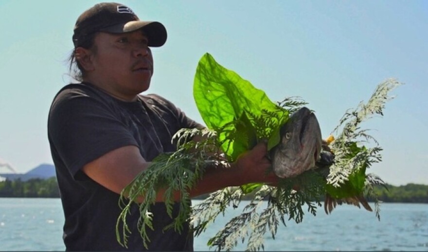 A file photo of a member of Puget Sound's Swinomish tribe participating in a ceremonial salmon blessing. Northwest tribes hold vigils along the Columbia River to pray for the return of salmon.