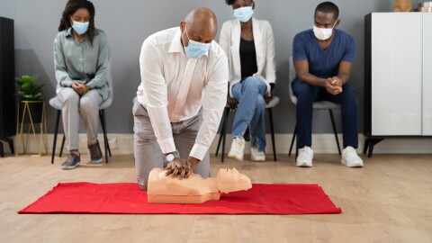 CPR First Aid Training With Paramedic Instructor In Face Mask