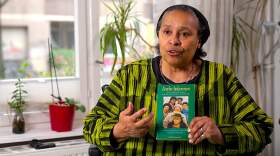 Katharina Oguntoye holding her book "Farbe bekennen." (Courtesy of Widen the Circle)