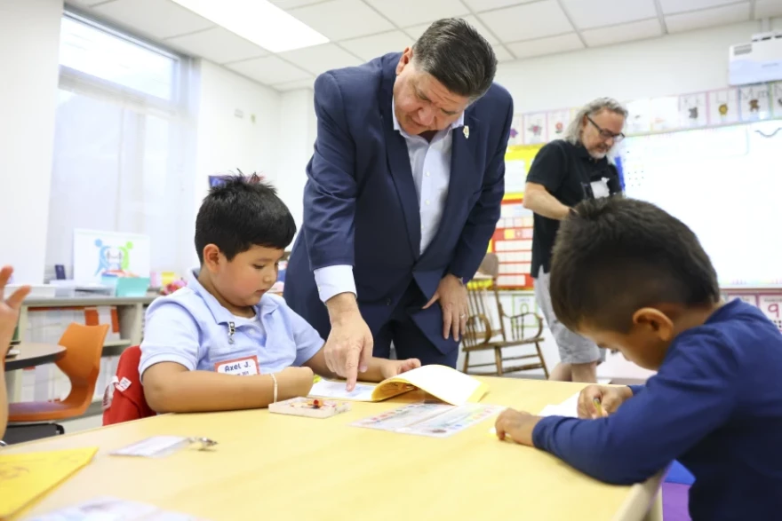 Gov. JB Pritzker speaks helps a kindergarten student at Prairie Oak Elementary School in Berwyn Sept. 4.